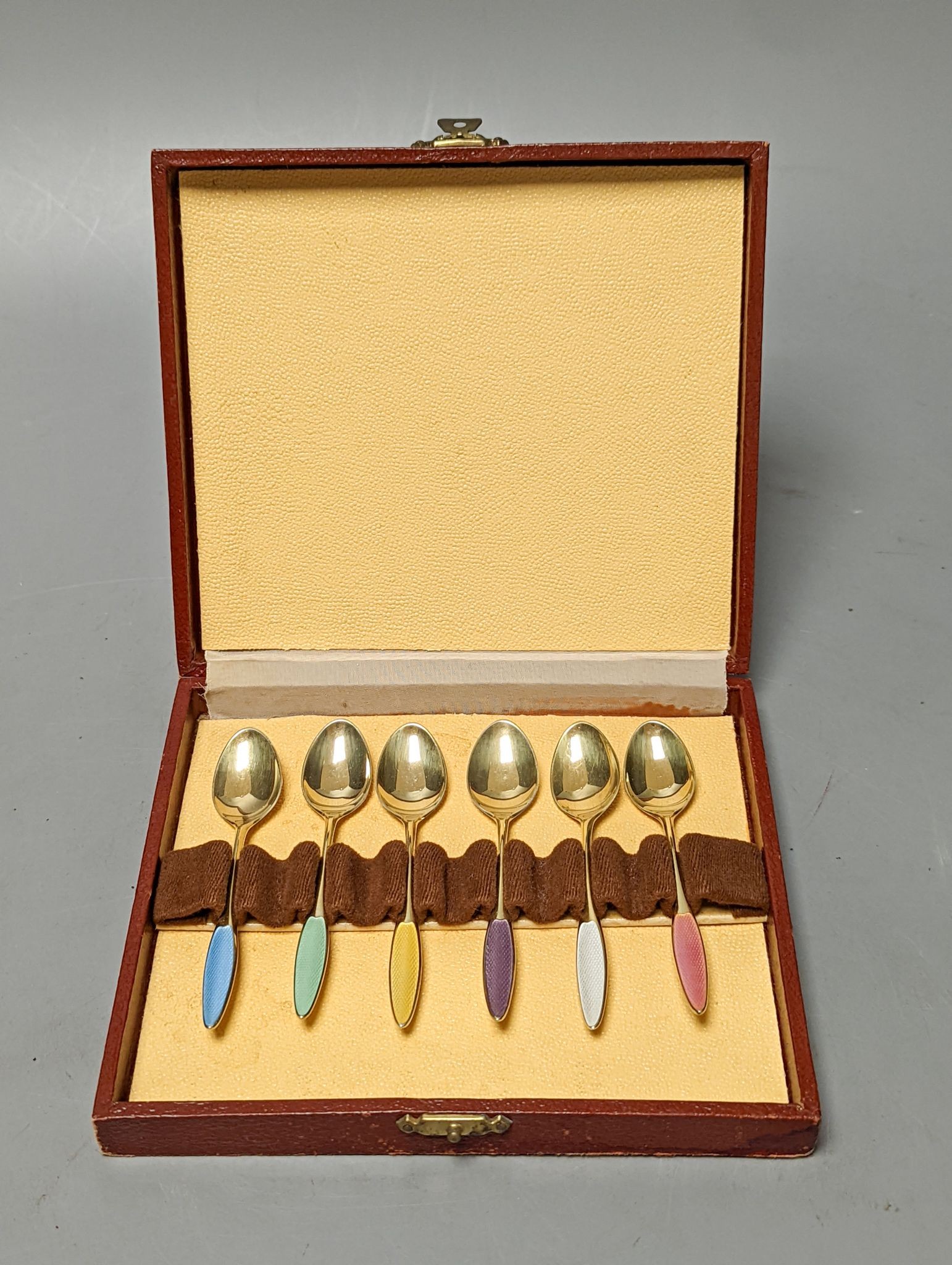 A cased set of six Danish Fricast gilt sterling and enamel coffee spoons.